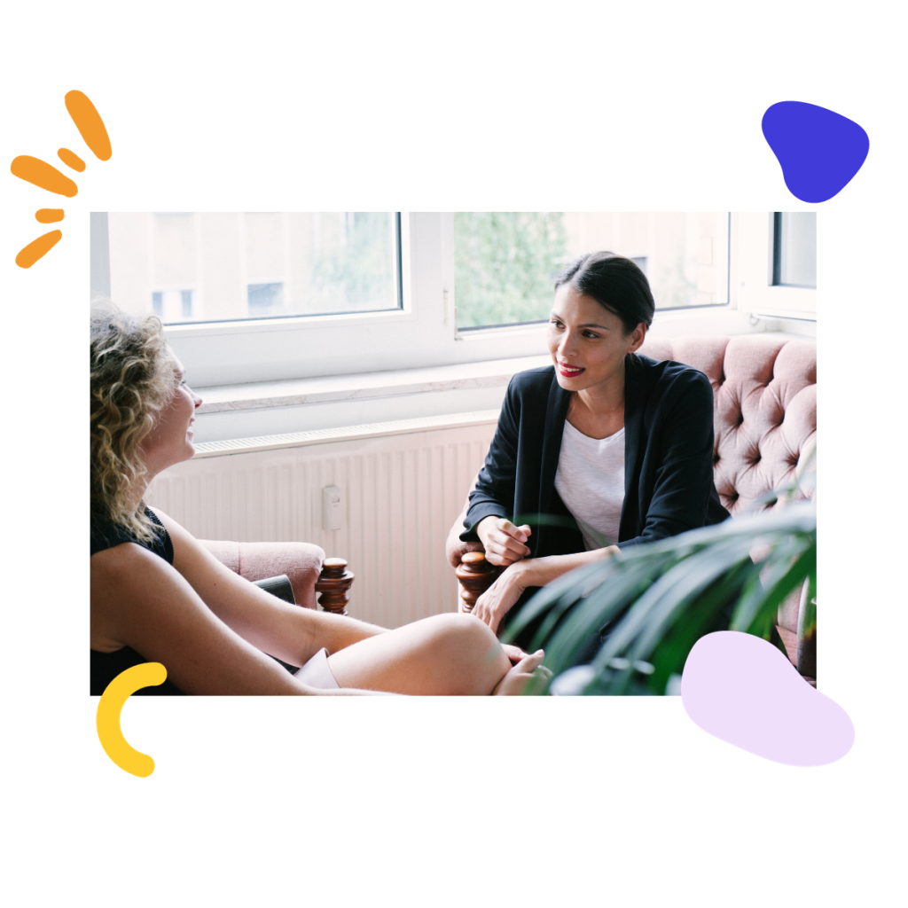 Two women sitting on a couch during a coaching session.